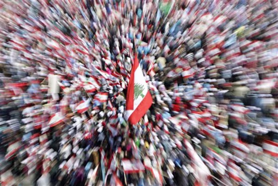 Lebanese people carry national flags as they attend a rally in Beirut's Martyrs' Square, Lebanon, on Sunday. Thousands of flag-waving Lebanese gathered in Beirut's main square Sunday to mark the sixth anniversary of the assassination of former Prime Minister Rafik Hariri, a killing that sparked a cascade of political turmoil in the Middle East. 